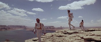 Movie still from “Planet of the Apes” (1968), directed by Franklin J. Schaffner – Two men in white space suits standing on a cliff; Wide shot, Low angle