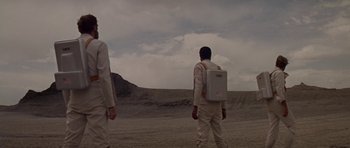 Movie still from “Planet of the Apes” (1968), directed by Franklin J. Schaffner – Two men in white suits are standing in the desert; Wide shot, Low angle