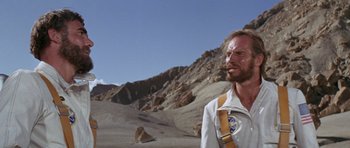 Movie still from “Planet of the Apes” (1968), directed by Franklin J. Schaffner – A man in a white shirt is standing in the desert; Close Up shot, Low angle