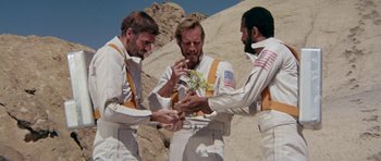 Movie still from “Planet of the Apes” (1968), directed by Franklin J. Schaffner – A group of men standing next to each other on top of a hill; Medium shot, Overhead angle