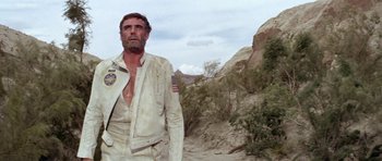Movie still from “Planet of the Apes” (1968), directed by Franklin J. Schaffner – A man in a white jacket standing on a dirt road; Medium shot, Low angle