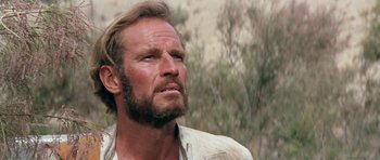 Movie still from “Planet of the Apes” (1968), directed by Franklin J. Schaffner – A man with long hair and a goatee looking up; Close Up shot, Low angle