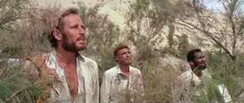 Movie still from “Planet of the Apes” (1968), directed by Franklin J. Schaffner – Two men standing next to each other near a bush; Close Up shot, Low angle