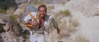 Movie still from “Planet of the Apes” (1968), directed by Franklin J. Schaffner – A man in a white suit running in the desert; Medium shot, Low angle