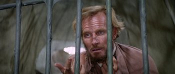 Movie still from “Planet of the Apes” (1968), directed by Franklin J. Schaffner – A man in a jail cell with his hand up to his face; Close Up shot, Low angle