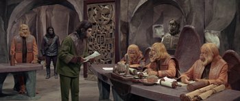 Movie still from “Planet of the Apes” (1968), directed by Franklin J. Schaffner – A group of people sitting around a table; Wide shot, High angle