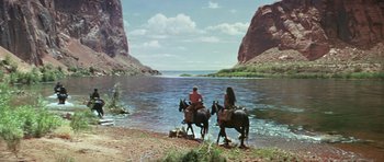 Movie still from “Planet of the Apes” (1968), directed by Franklin J. Schaffner – Two people on horseback near a body of water; Extreme Wide shot, High angle