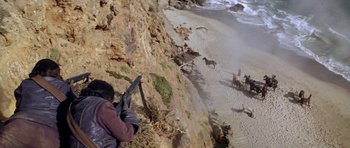 Movie still from “Planet of the Apes” (1968), directed by Franklin J. Schaffner – A man standing on top of a cliff next to the ocean; Wide shot, High angle