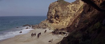 Movie still from “Planet of the Apes” (1968), directed by Franklin J. Schaffner – A group of people riding horses on a beach; Extreme Wide shot, High angle