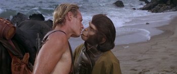 Movie still from “Planet of the Apes” (1968), directed by Franklin J. Schaffner – A man and a monkey face each other on the beach; Close Up shot, Over the shoulder angle