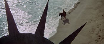 Movie still from “Planet of the Apes” (1968), directed by Franklin J. Schaffner – A person riding a horse on a beach near the ocean; Extreme Wide shot, High angle