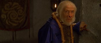 Movie still from “Planet of the Apes” (2001), directed by Tim Burton – An old man with white hair wearing a blue robe; Close Up shot, Over the shoulder angle