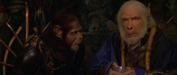 Movie still from “Planet of the Apes” (2001), directed by Tim Burton – A man and a monkey sitting next to each other; Close Up shot, Over the shoulder angle
