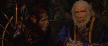Movie still from “Planet of the Apes” (2001), directed by Tim Burton – Two people sitting next to each other in a forest; Close Up shot, Over the shoulder angle