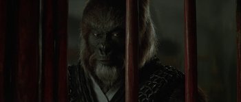 Movie still from “Planet of the Apes” (2001), directed by Tim Burton – A man with a gorilla mask holding a sword in the dark; Close Up shot, Over the shoulder angle