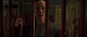 Movie still from “Planet of the Apes” (2001), directed by Tim Burton – A woman looking through bars in a room; Close Up shot, Low angle