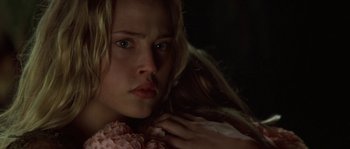 Movie still from “Planet of the Apes” (2001), directed by Tim Burton – A young woman with long blonde hair is holding a pink flower; Close Up shot, Over the shoulder angle