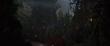 Movie still from “Planet of the Apes” (2001), directed by Tim Burton – A group of people sitting in front of a forest at night; Extreme Wide shot, Low angle