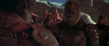 Movie still from “Planet of the Apes” (2001), directed by Tim Burton – A man in a gorilla costume in front of a group of people; Medium shot, Low angle