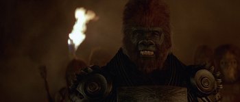 Movie still from “Planet of the Apes” (2001), directed by Tim Burton – A man in a gorilla costume with fire in the background; Close Up shot, Low angle