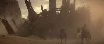 Movie still from “Planet of the Apes” (2001), directed by Tim Burton – A group of people riding horses in a dusty area; Extreme Wide shot, Low angle