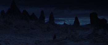 Movie still from “Planet of the Apes” (2001), directed by Tim Burton – A person riding a horse in the middle of the night; Extreme Wide shot, High angle