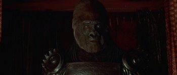 Movie still from “Planet of the Apes” (2001), directed by Tim Burton – A man in a gorilla suit sitting in a chair; Close Up shot, Over the shoulder angle