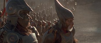 Movie still from “Planet of the Apes” (2001), directed by Tim Burton – A group of people in costumes in the middle of a field; Close Up shot, Over the shoulder angle