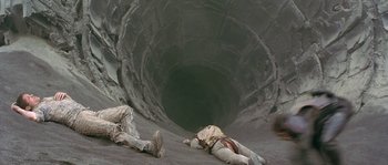 Movie still from “Planet of the Apes” (2001), directed by Tim Burton – Two soldiers laying on the ground near a tunnel; Wide shot, High angle
