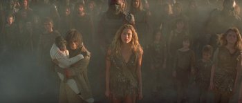 Movie still from “Planet of the Apes” (2001), directed by Tim Burton – A group of people standing around a woman in front of a crowd; Wide shot, High angle