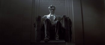 Movie still from “Planet of the Apes” (2001), directed by Tim Burton – A statue of abraham lincoln sitting in a chair; Extreme Close Up shot, Low angle
