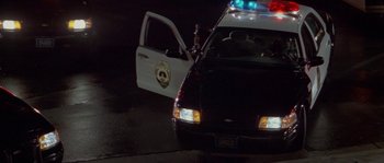 A police car parked on the side of the road at night