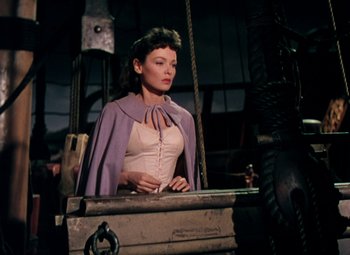 Movie still from “Plymouth Adventure” (1952), directed by Clarence Brown – A woman standing in front of an old trunk; Medium shot, High angle