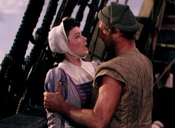 Movie still from “Plymouth Adventure” (1952), directed by Clarence Brown – A man and a woman embracing each other on a bridge; Medium shot, Low angle