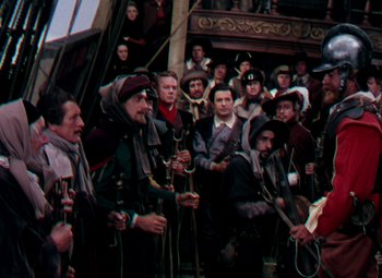 Movie still from “Plymouth Adventure” (1952), directed by Clarence Brown – A group of people standing around a building; Wide shot, High angle