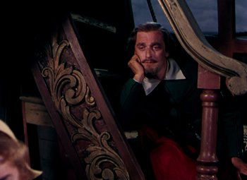 Movie still from “Plymouth Adventure” (1952), directed by Clarence Brown – A man sitting on top of a wooden stair railing; Medium shot, High angle
