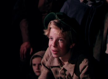 Movie still from “Plymouth Adventure” (1952), directed by Clarence Brown – A young boy wearing a green hat and a brown jacket; Close Up shot, Over the shoulder angle