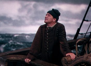 Movie still from “Plymouth Adventure” (1952), directed by Clarence Brown – A man standing on top of a boat in the water; Medium shot, Low angle