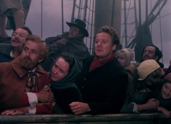 Movie still from “Plymouth Adventure” (1952), directed by Clarence Brown – A group of people sitting on a boat in the water; Medium shot, High angle