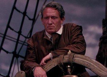 Movie still from “Plymouth Adventure” (1952), directed by Clarence Brown – An older man sitting in a boat on a cloudy day; Close Up shot, High angle