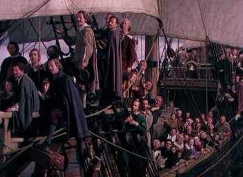 Movie still from “Plymouth Adventure” (1952), directed by Clarence Brown – A crowd of people sitting on top of a boat; Extreme Wide shot, High angle