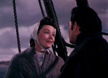 Movie still from “Plymouth Adventure” (1952), directed by Clarence Brown – A woman in a fur coat and a man in a black coat; Close Up shot, Over the shoulder angle