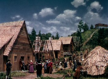Movie still from “Plymouth Adventure” (1952), directed by Clarence Brown – A painting of people standing in front of houses; Extreme Wide shot, High angle