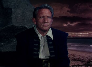 Movie still from “Plymouth Adventure” (1952), directed by Clarence Brown – An older man wearing a pirate costume in front of the ocean; Medium shot, Low angle