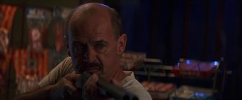 Movie still from “Point of No Return” (1993), directed by John Badham – A man with a beard and a microphone in his mouth; Close Up shot, Low angle