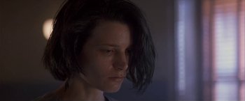 Movie still from “Point of No Return” (1993), directed by John Badham – A person's face in a dark room; Close Up shot, Low angle