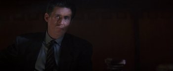 Movie still from “Point of No Return” (1993), directed by John Badham – A person wearing a suit and tie; Close Up shot, Low angle
