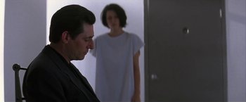 Movie still from “Point of No Return” (1993), directed by John Badham – A man and a woman standing next to each other in front of a door; Medium shot, Over the shoulder angle
