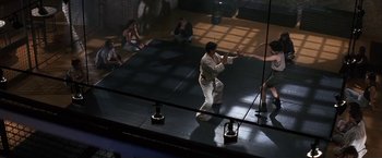 Movie still from “Point of No Return” (1993), directed by John Badham – A man in a white shirt is on a boxing ring; Wide shot, Low angle