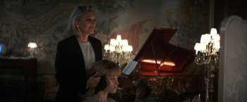 Movie still from “Point of No Return” (1993), directed by John Badham – A woman standing next to a woman in front of a grand piano; Medium shot, Over the shoulder angle